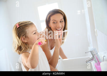 Madre e figlia in bagno spazzolare i suoi denti Foto Stock