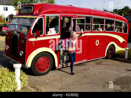 Donna scendono dagli anni cinquanta albion bus vintage mentre in un tour dell'area locale di frensham, surrey, Regno Unito. Il 28 ottobre 2017. Foto Stock