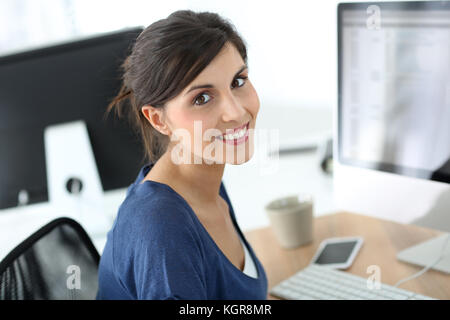 Bruna sorridente ragazza in classe di formazione Foto Stock