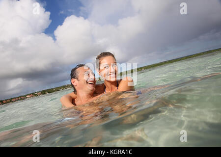 Allegro di mezza età matura abbracciando in mare Foto Stock