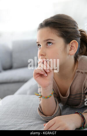 Ragazza giovane la posa sul lettino con sguardo premuroso Foto Stock