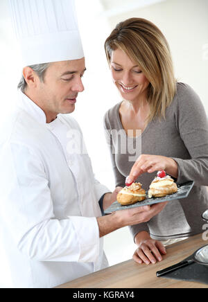 Pasticcere avente donna pasticceria degustazione Foto Stock