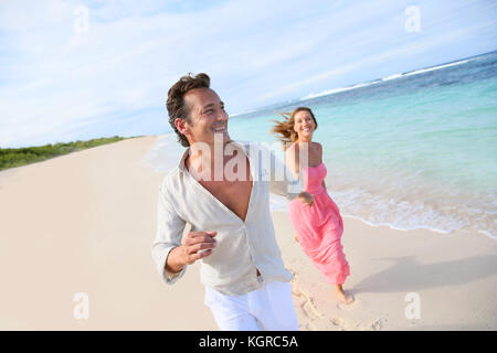 Giovane divertendosi in esecuzione su una spiaggia caraibica Foto Stock