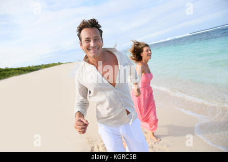 Giovane divertendosi in esecuzione su una spiaggia caraibica Foto Stock