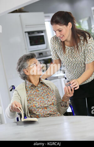 Ritratto di donna anziana in carrozzina con home caregiver Foto Stock