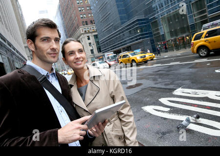 La gente di affari utilizzando tablet nelle strade di Manhattan Foto Stock