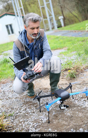 L'uomo operando un drone con telecomando Foto Stock