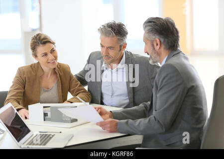 Coppia matura incontro architetto per il progetto di costruzione Foto Stock