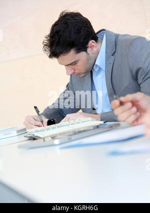 Giovane uomo riempiendo il modulo di domanda Foto Stock