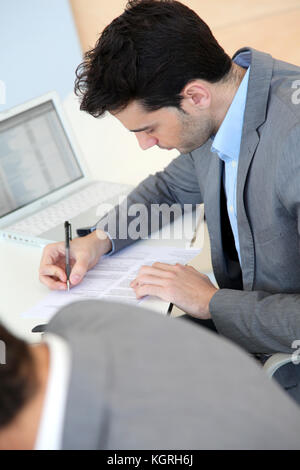 Giovane uomo riempiendo il modulo di domanda Foto Stock