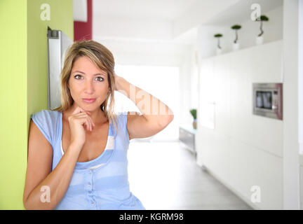 Il 30-anno-vecchia donna in piedi nella cucina di casa Foto Stock