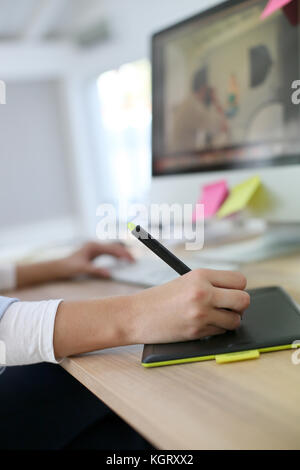 Primo piano della mano lavorando sulla tavoletta grafica Foto Stock