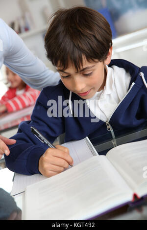 Giovani schoolboy seduta in aula Foto Stock