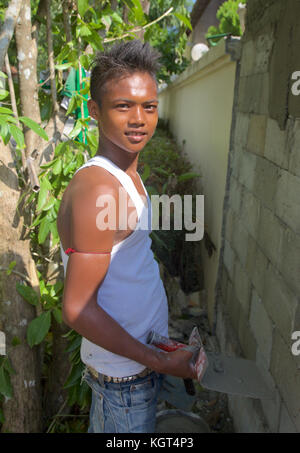 Un giovane ragazzo birmano lavorando su un sito di costruzione in Phuket Thailandia. Foto Stock