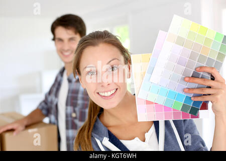 Sorridente ragazza con i grafici a colori per decorare house Foto Stock