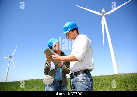 Ingegneri guardando al sito della turbina eolica con la compressa Foto Stock