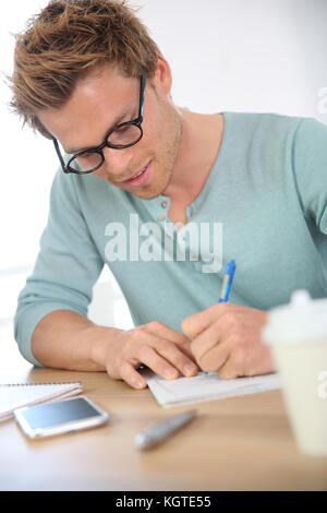 Ritratto di giovane uomo riempiendo il modulo di domanda Foto Stock