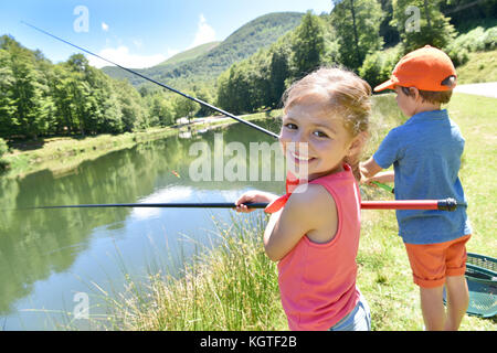 Ritratto di bambina la pesca di lago di montagna Foto Stock