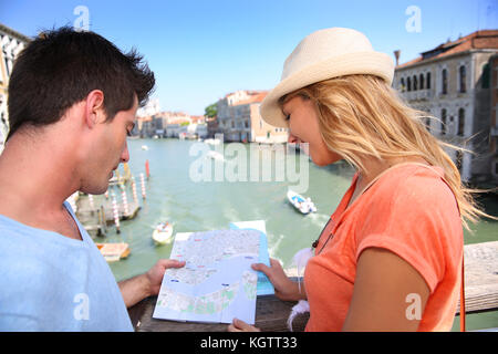 Couplelooking a mappa sul ponte dell'Accademia di Venezia, Italia Foto Stock