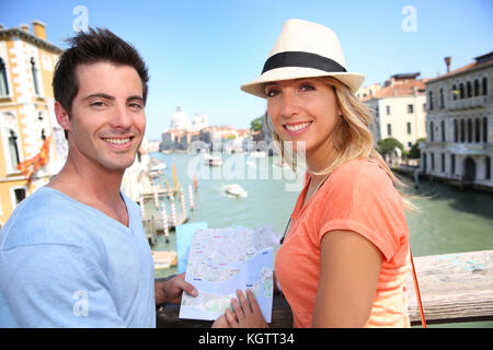 Couplelooking a mappa sul ponte dell'Accademia di Venezia, Italia Foto Stock