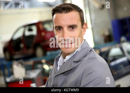 Ritratto del carrozziere in piedi in autoshop Foto Stock