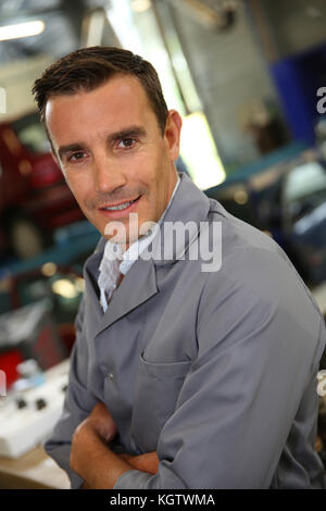 Ritratto del carrozziere in piedi in autoshop Foto Stock