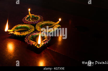 Diwali decorazioni con indiani tradizionali lampade a olio con messa a fuoco selettiva su un tavolo di legno. sia di primo piano e di sfondo sono sfocate. Foto Stock