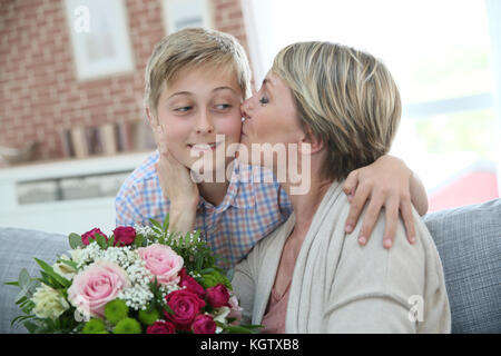 Donna kissing little boy per la festa della mamma Foto Stock