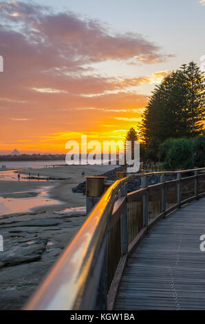 Passeggiata al tramonto lungo la passerella in spiaggia - spettacolo di luci di fine giornata Foto Stock