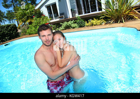 Coppia giovane nella piscina privata Foto Stock