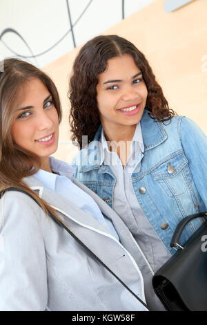 Gli studenti universitari in piedi nella hall con valigetta Foto Stock