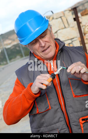 Lavoratore con casco di sicurezza installazione sistema di gate Foto Stock