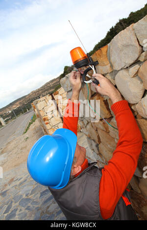 Lavoratore con casco di sicurezza installazione sistema di gate Foto Stock