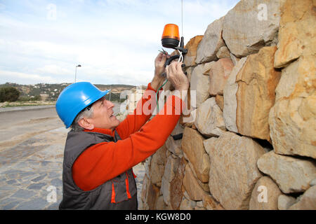 Lavoratore con casco di sicurezza installazione sistema di gate Foto Stock