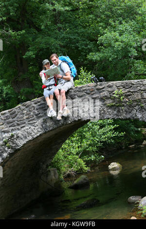 Paio di escursionisti mappa di lettura sul ponte di pietra Foto Stock