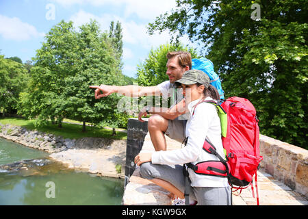 Gli escursionisti guardando il fiume dalla pietra ponte romano Foto Stock