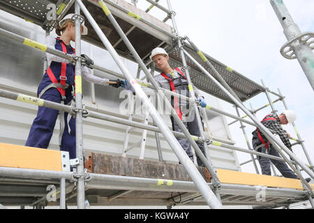 Lavoratori edili installazione ponteggio sul sito Foto Stock