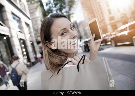Allegro shopping Ragazza di Manhattan e parlando al telefono Foto Stock