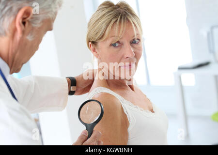 Donna anziana consulting medico per il controllo della pelle Foto Stock
