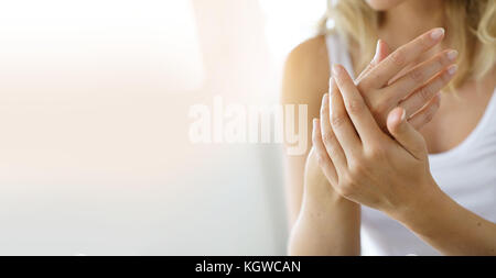 Primo piano sulla donna applicando le mani mano idratante-crema su Foto Stock