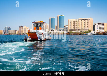 Dubai, Emirati arabi uniti - 26oct2017: barca raccolta rifiuti galleggianti da Dubai Creek. Foto Stock