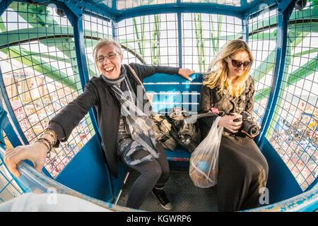 Due donne godendo di una corsa su di Dino Wonder Wheel ruota panoramica Ferris, Coney Island, Brooklyn, New York, Stati Uniti d'America. Foto Stock