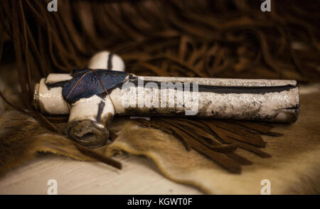 Soft focus di metallo e ceramica artigianale di croce sulla pelle di mucca e stringhe in pelle Foto Stock