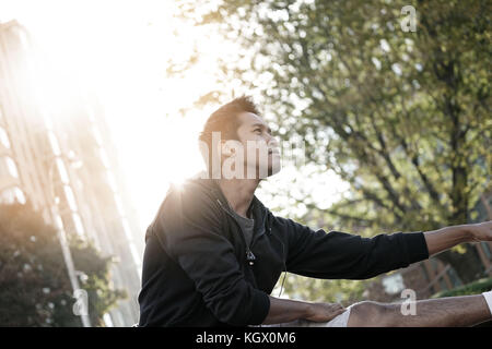 Asian guy stirando dopo esercizio Foto Stock