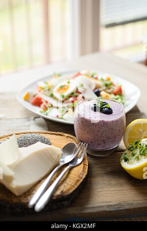 Chia frullato di mirtilli e insalata fresca, mangiare sano concetto, posto su una tavola di legno accanto alla finestra, fatti in casa mangiare sano concetto Foto Stock