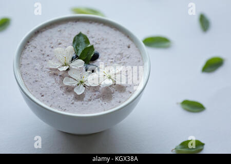 Farina di avena porridge realizzato di avena, purea di banana, latte di mandorla e frutti di bosco, tutti mescolati insieme, isolato su sfondo bianco Foto Stock