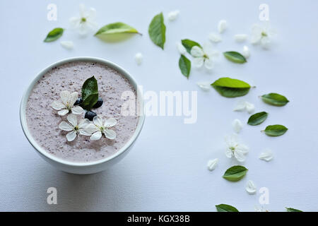 Farina di avena porridge realizzato di avena, purea di banana, latte di mandorla e frutti di bosco, tutti mescolati insieme, isolato su sfondo bianco Foto Stock