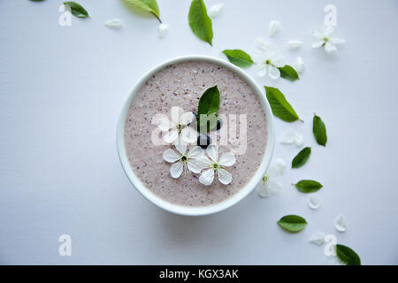 Farina di avena porridge realizzato di avena, purea di banana, latte di mandorla e frutti di bosco, tutti mescolati insieme, isolato su sfondo bianco Foto Stock