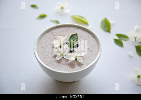 Farina di avena porridge realizzato di avena, purea di banana, latte di mandorla e frutti di bosco, tutti mescolati insieme, isolato su sfondo bianco Foto Stock