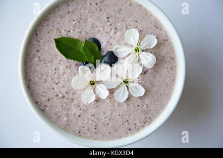 Farina di avena porridge realizzato di avena, purea di banana, latte di mandorla e frutti di bosco, tutti mescolati insieme, isolato su sfondo bianco Foto Stock